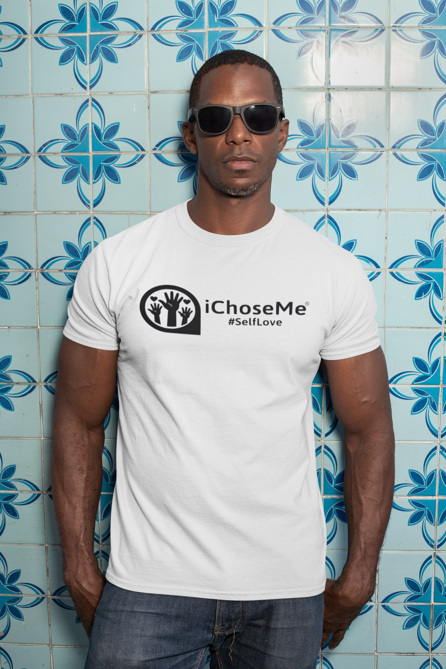 White iChoseMe self love graphic t-shirt worn by man with sunglasses against blue tiled wall