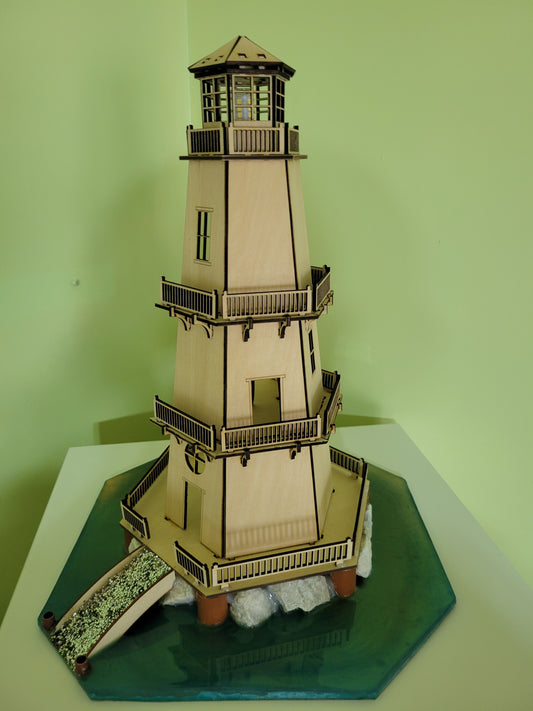Wooden lighthouse model featuring intricate railings, balconies, and a simulated rocky base with water.
