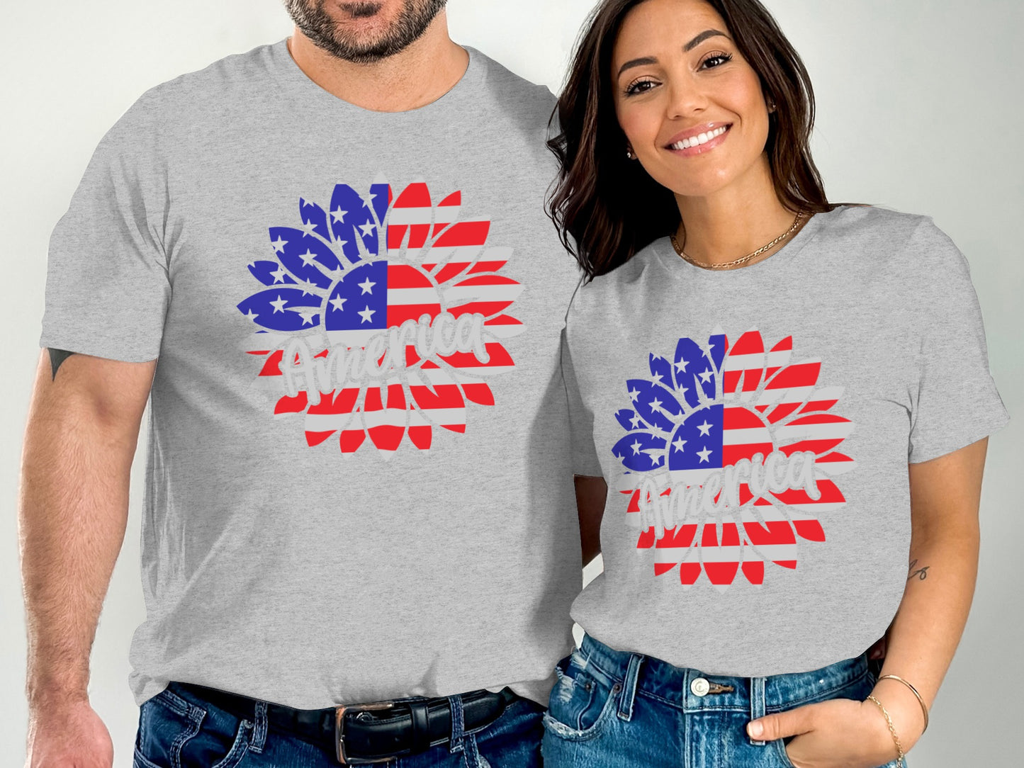 Two people wear matching grey t-shirts with an American flag sunflower design.