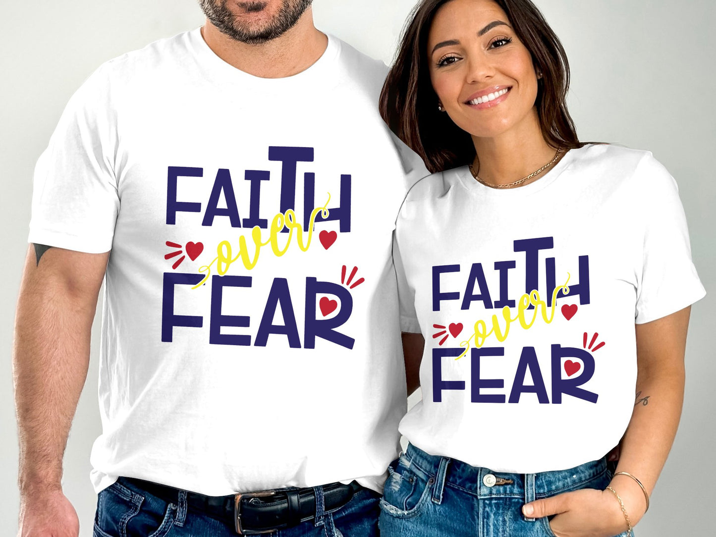 Couple wearing matching white Faith Over Fear t-shirts with bold navy and yellow text design