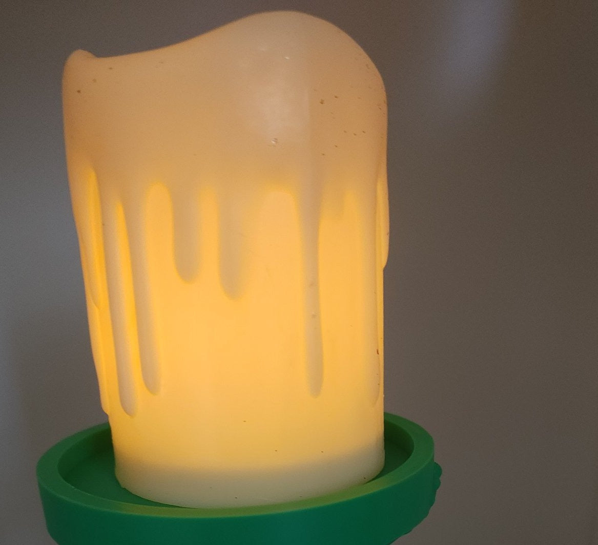 LED candle glowing in the Grinch candle holder tray