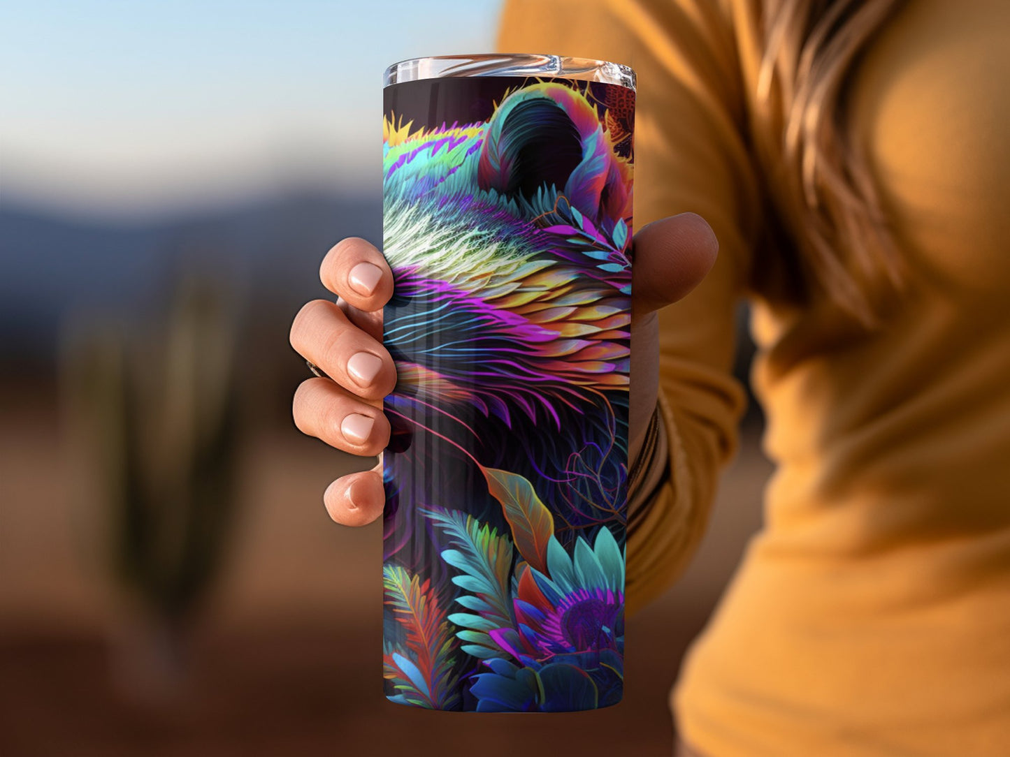 Bates Custom Creations vibrant racoon print tumbler held by person in orange sweater outdoors