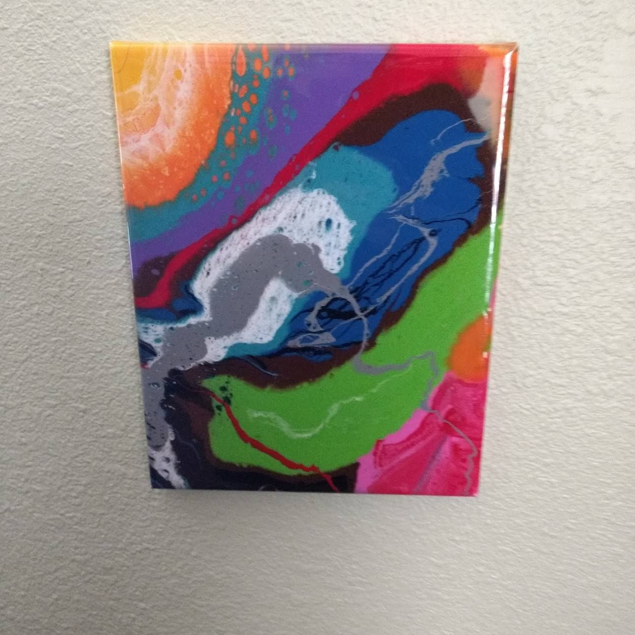 Colorful vibrant abstract wall art with swirling patterns in orange, blue, green, pink, and purple hues