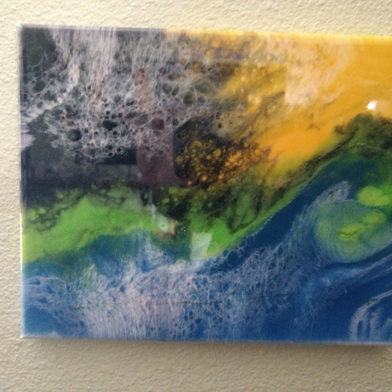 Colorful custom abstract wall art with vibrant blue, green, yellow, and black fluid patterns on canvas
