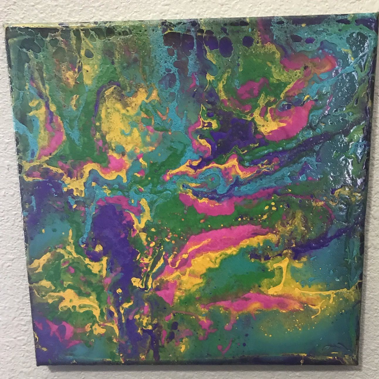 Abstract vibrant dragon artwork with swirling green, yellow, pink, and purple colors on canvas