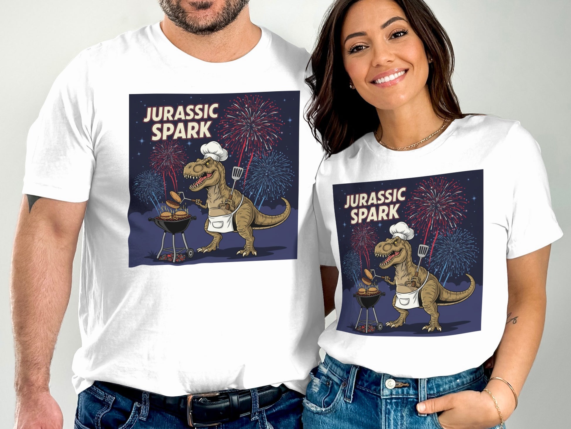 T-shirt graphic of a dinosaur grilling with fireworks, reading "Jurassic Spark".