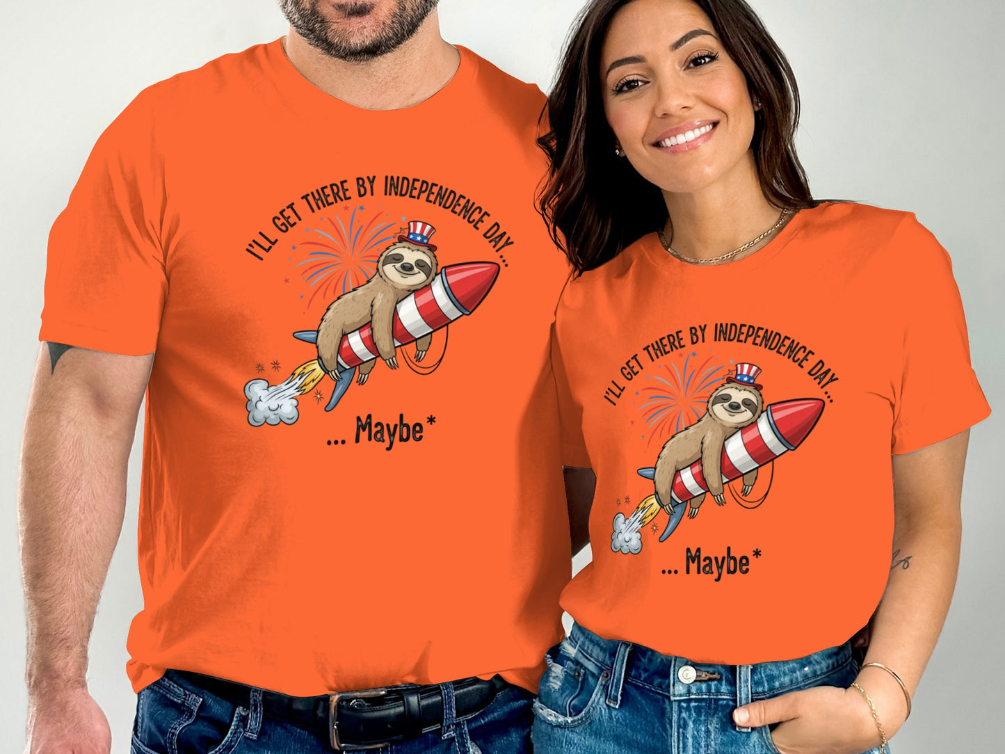 Two people wear orange t-shirts with a sloth riding a rocket and text.