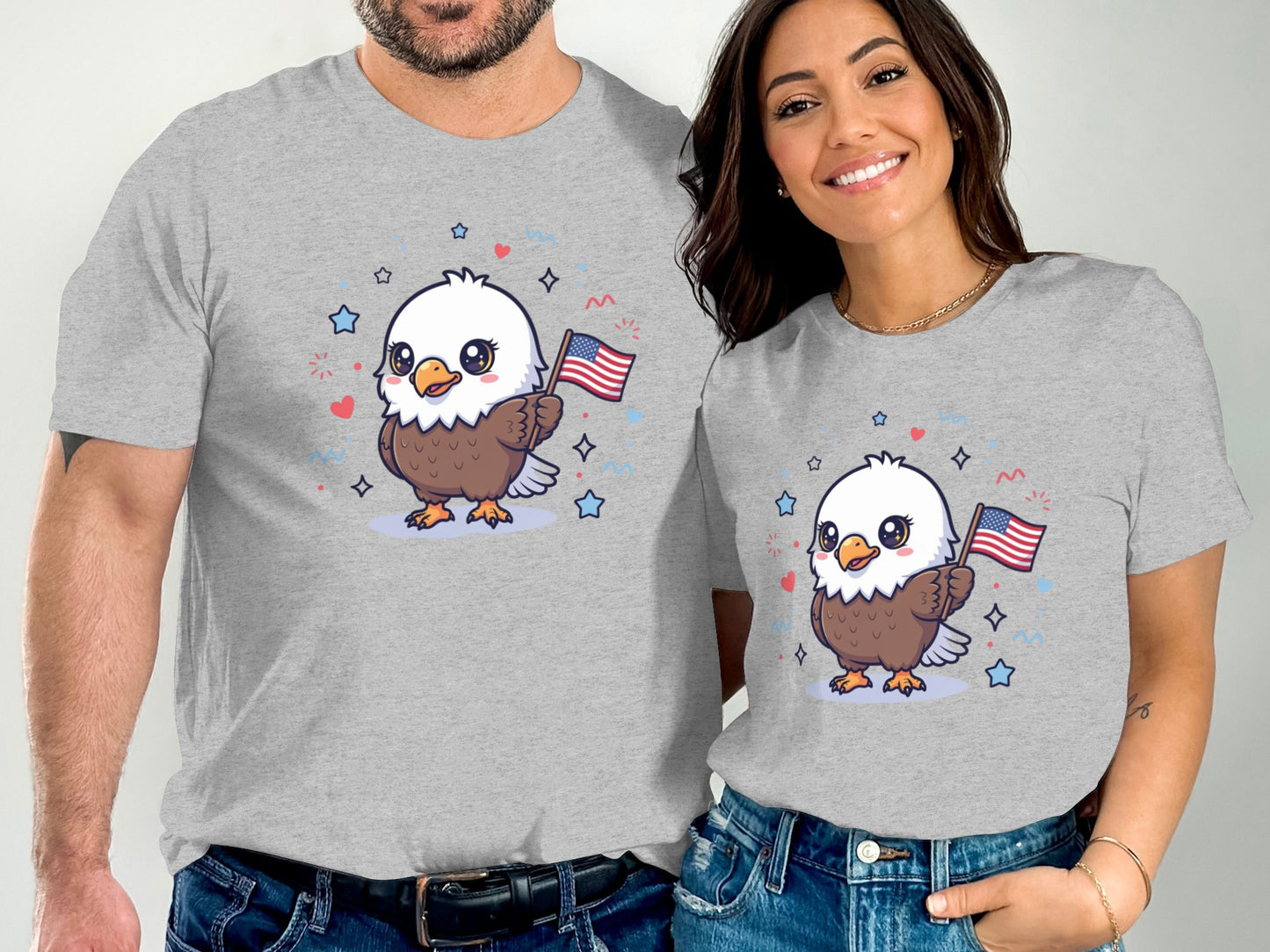 Couple wearing matching grey t-shirts with cartoon bald eagle holding American flag.