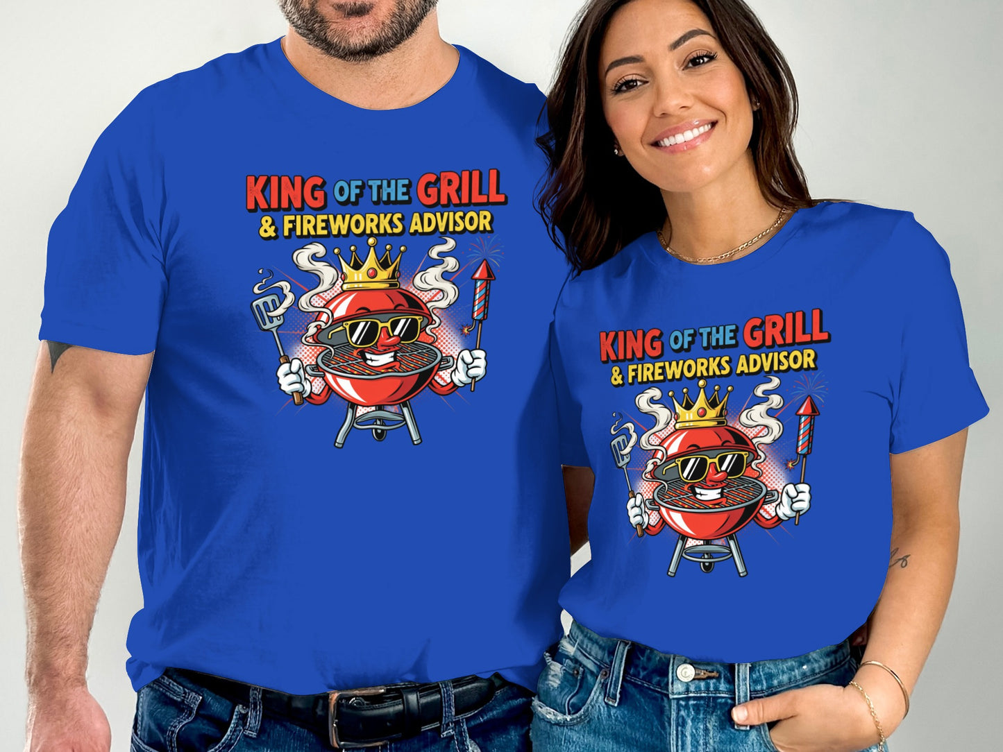 Couple wearing blue t-shirts with "King of the Grill & Fireworks Advisor" graphic.