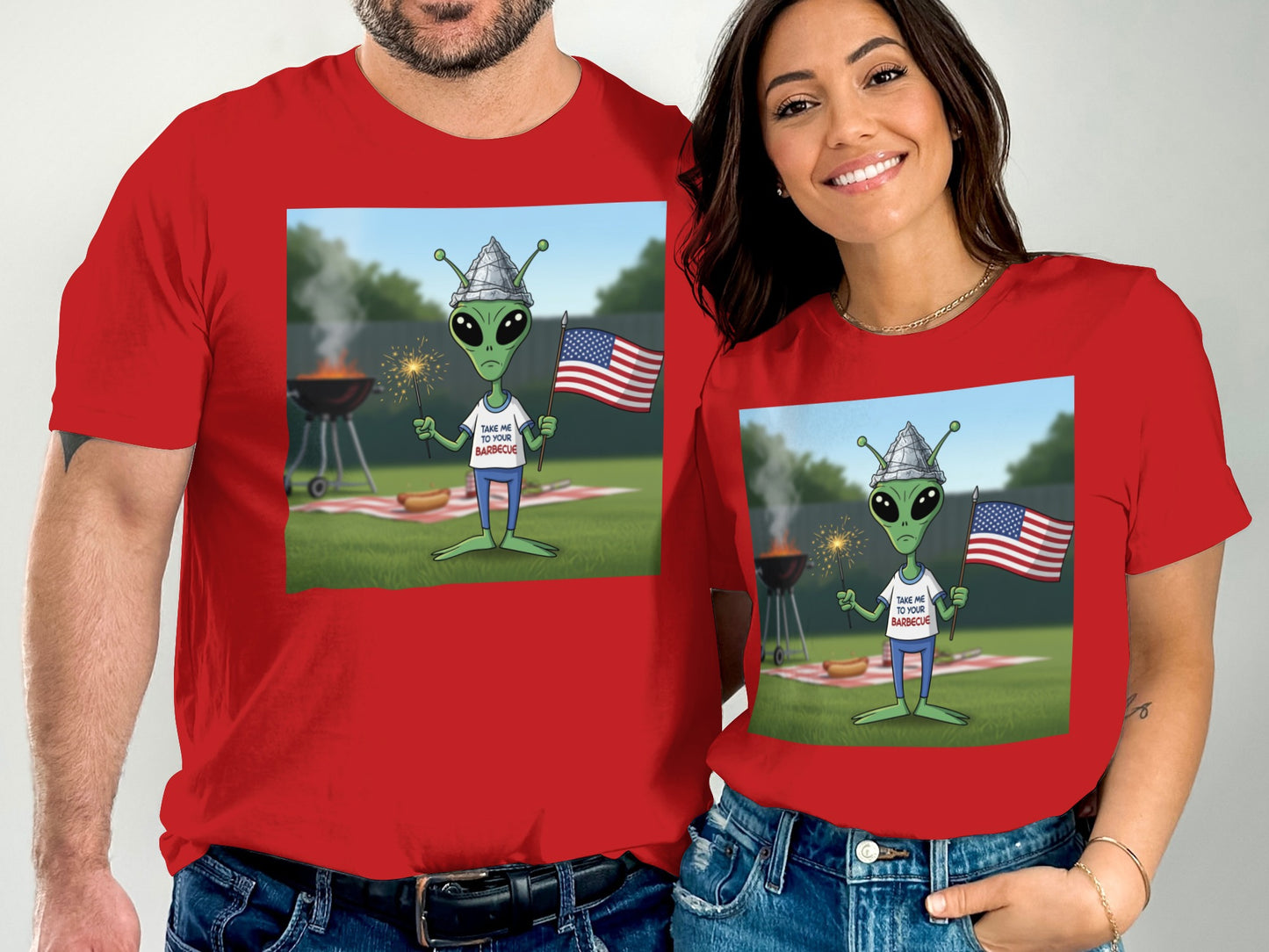 Red t-shirt with cartoon alien holding American flag at barbecue.