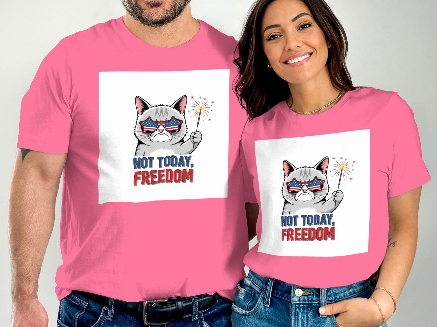 Two people wearing pink t-shirts with a patriotic cat graphic.