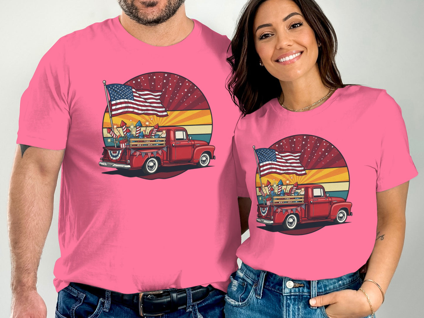 Two people wearing pink t-shirts with a red truck, American flag, and fireworks.