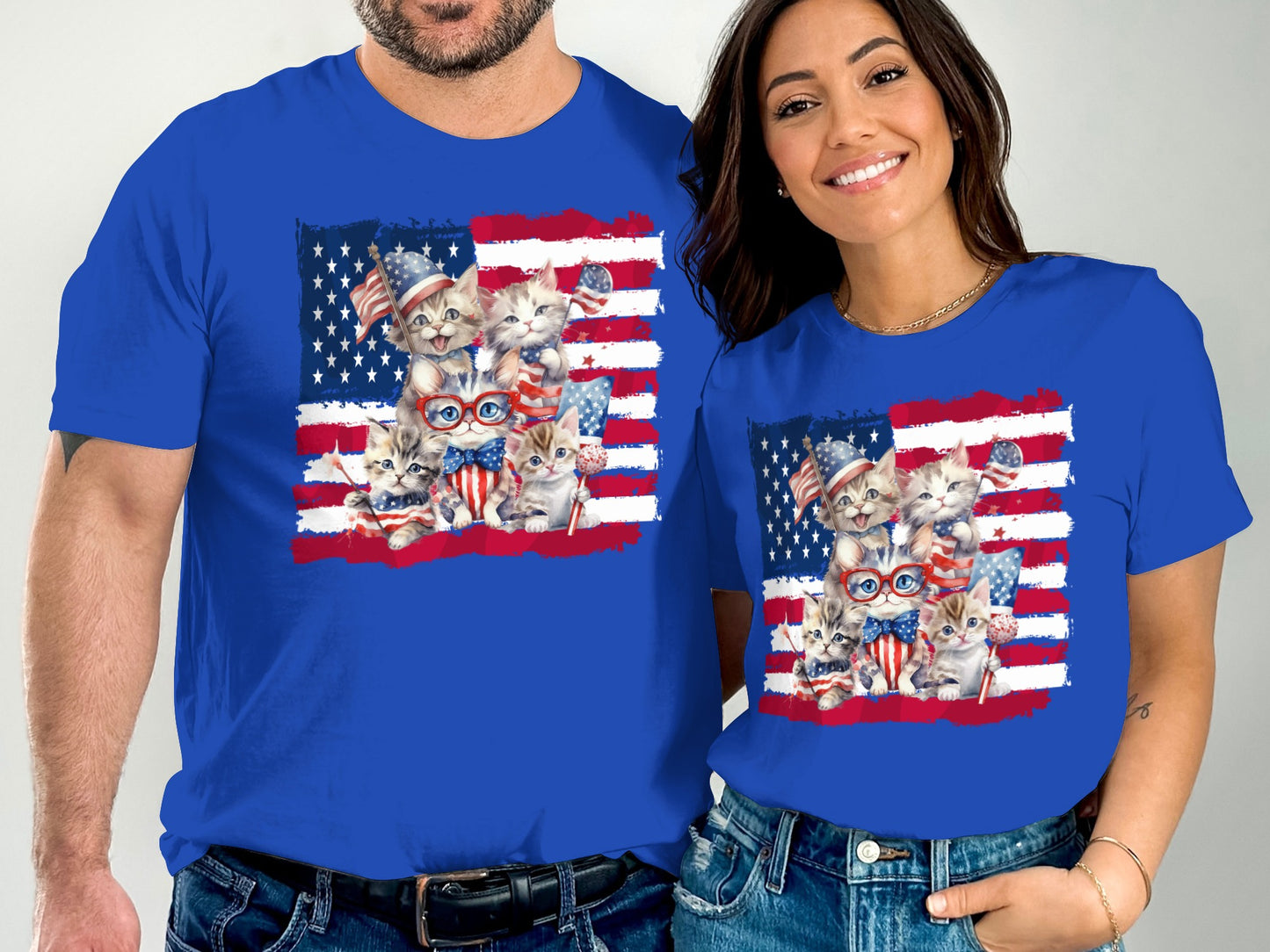 Two people wearing blue t-shirts with a group of kittens wearing patriotic accessories.