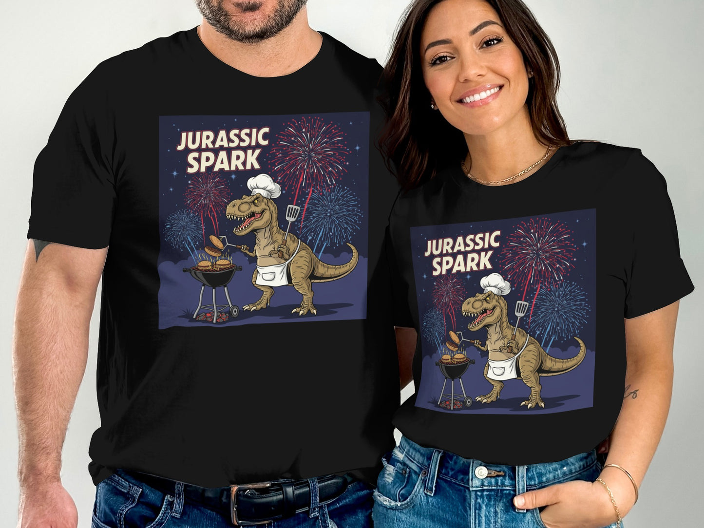 Couple wearing black t-shirts with Jurassic Park dinosaur grilling graphic.