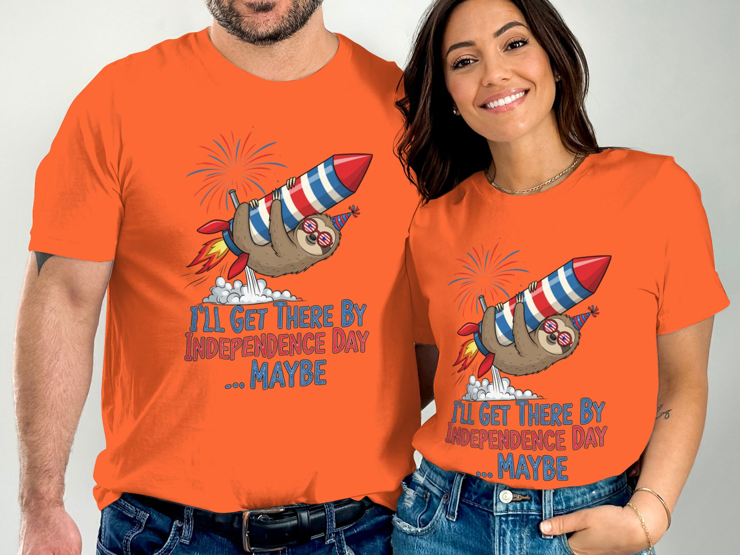 Orange t-shirts with sloth riding rocket and "I'll Get There By Independence Day... Maybe" text.