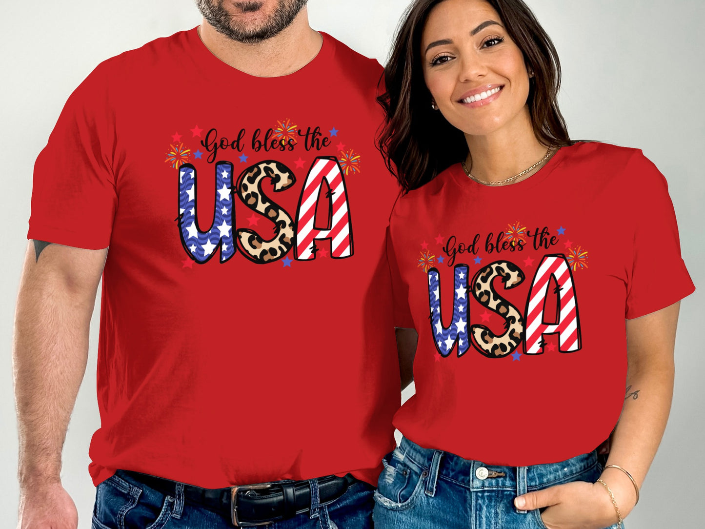 Couple wearing matching red t-shirts with "God bless the USA" and American flag design.