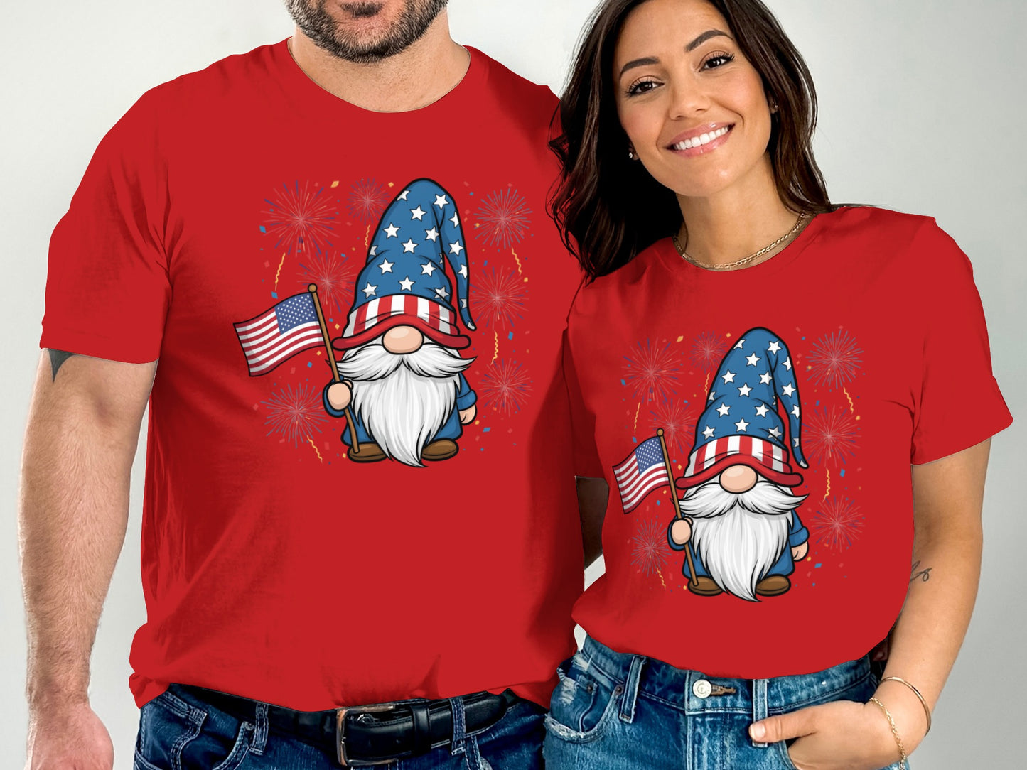 Couple wearing matching red t-shirts with gnome and fireworks graphic.