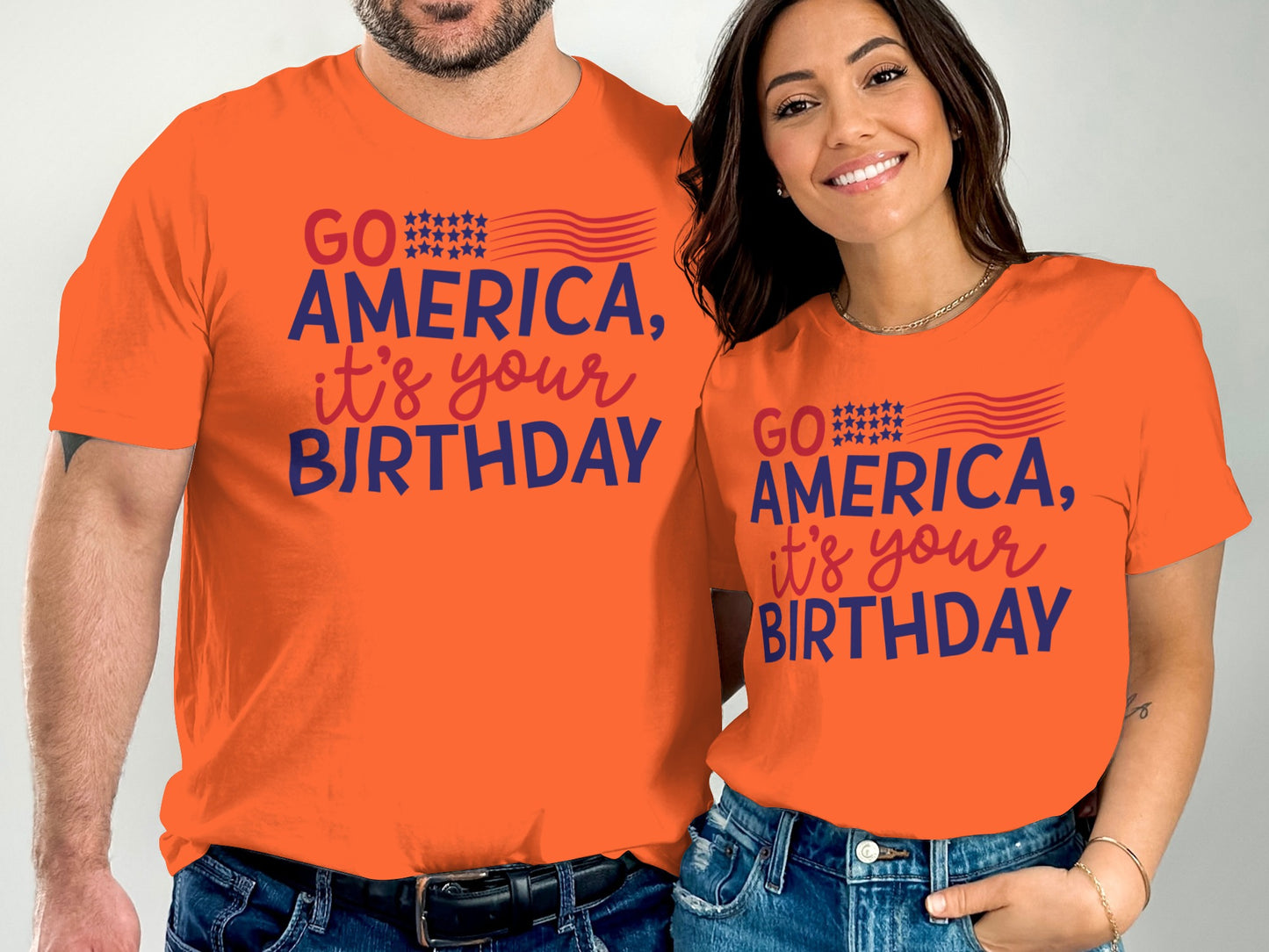 Couple wearing matching orange "Go America, it's your birthday" t-shirts.