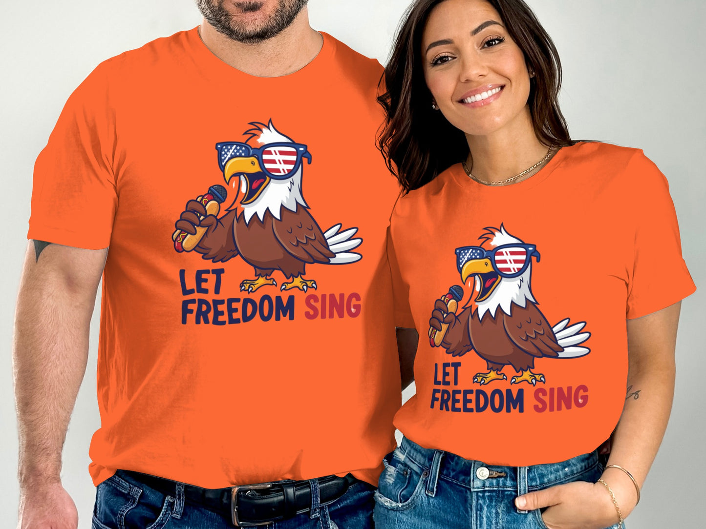 Two people wearing orange t-shirts with an eagle singing "Let Freedom Sing."