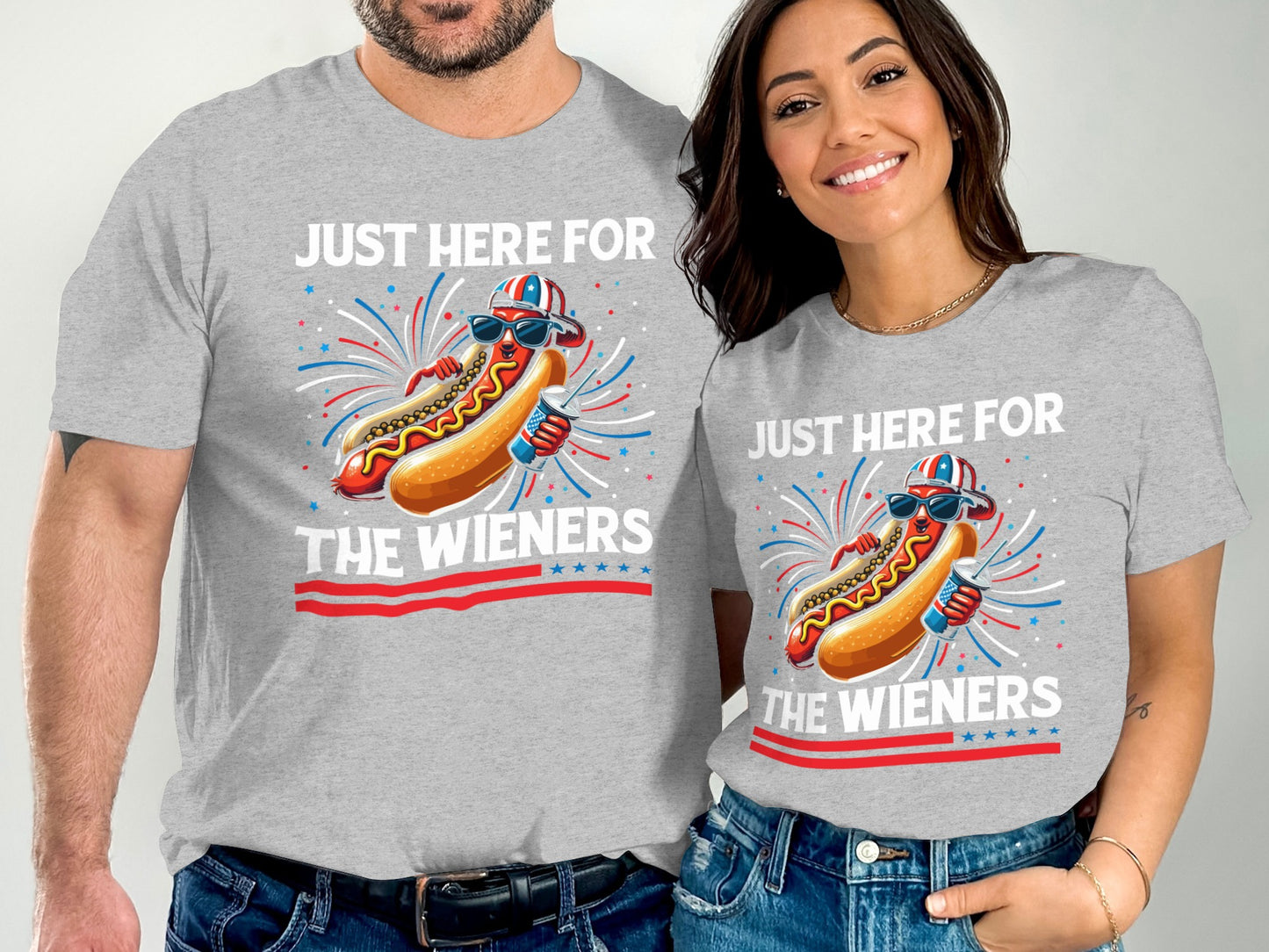 Couple wearing matching gray t-shirts with "Just Here For The Wieners" hot dog graphic.