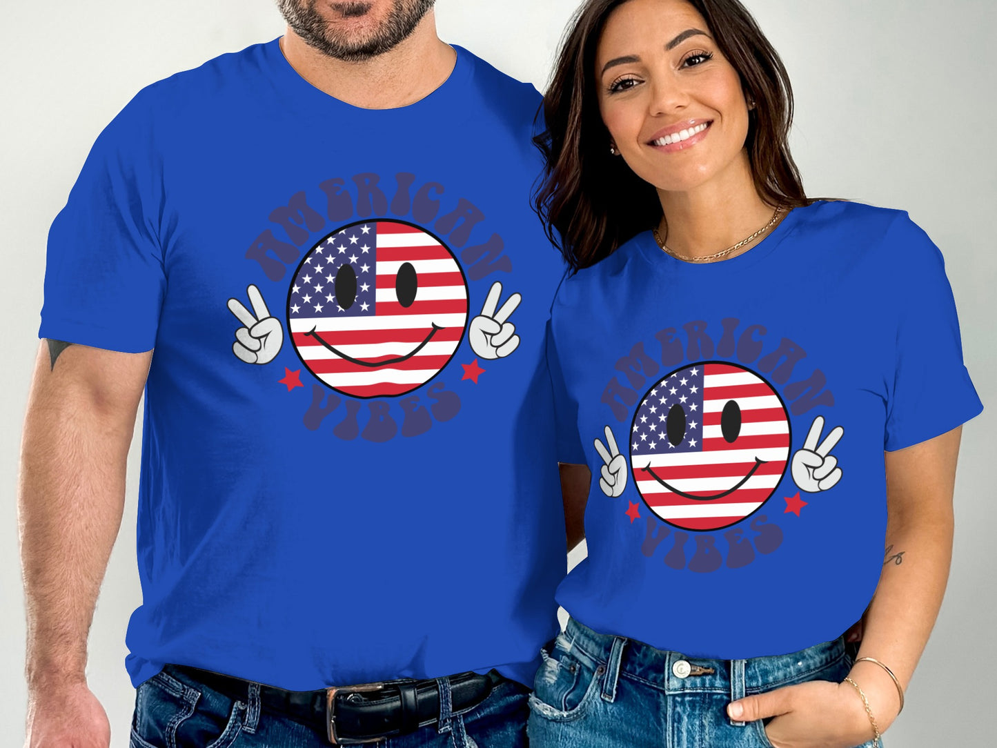 Two people in blue t-shirts with American flag smiley face and peace signs.