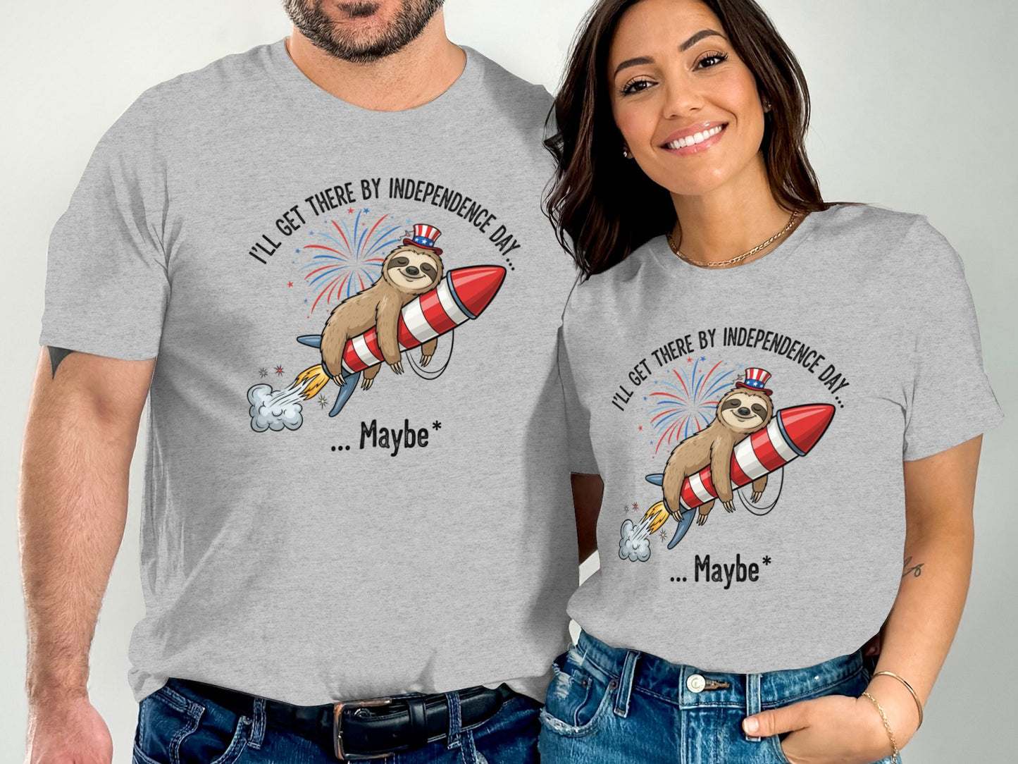 Two people wearing grey t-shirts with a sloth on a rocket and Independence Day text.