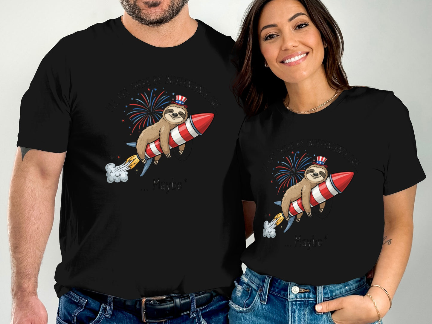 Couple wearing matching black t-shirts with a sloth on a rocket and fireworks.