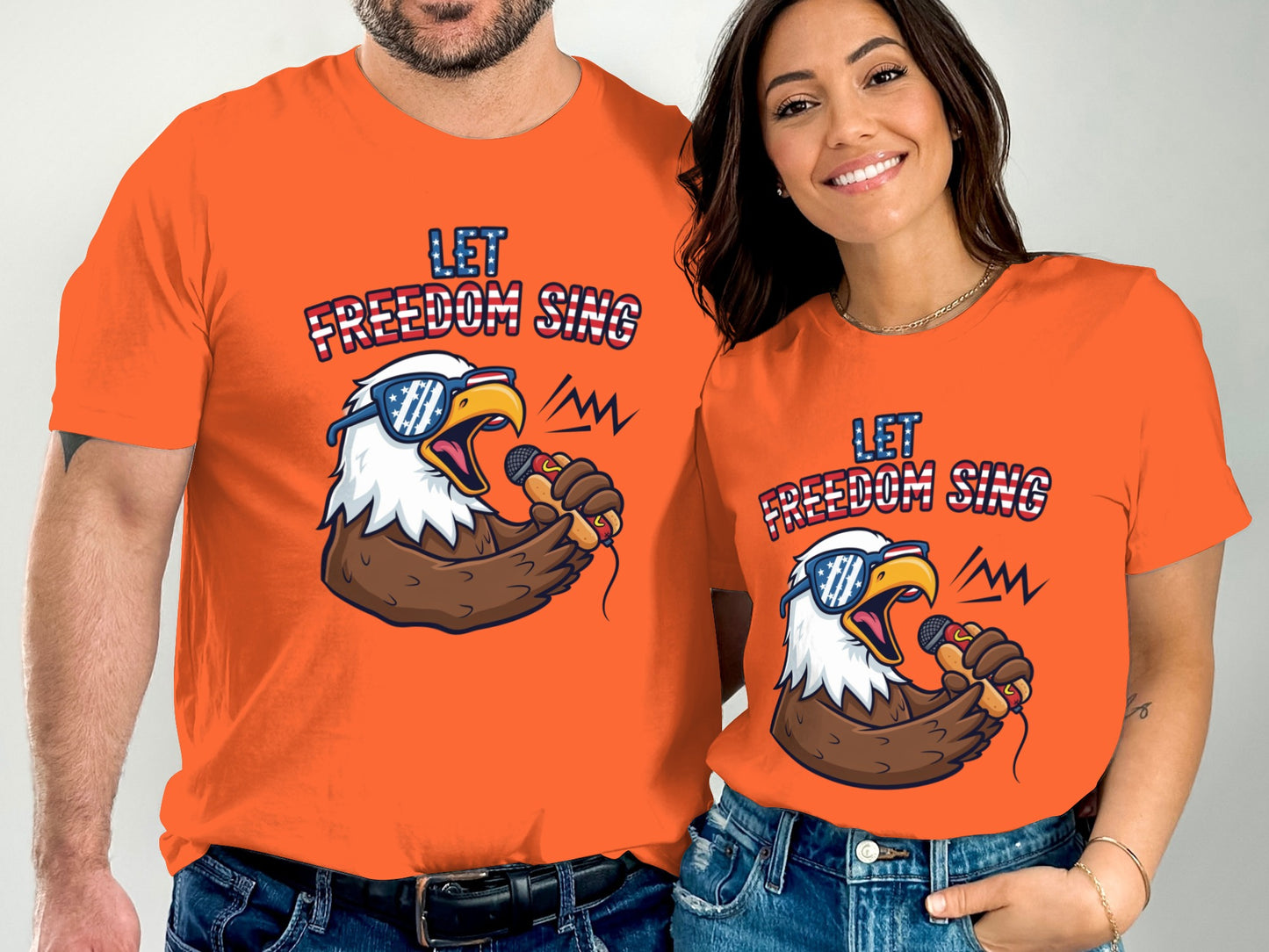 Couple wearing matching orange t-shirts with an eagle singing into a microphone.