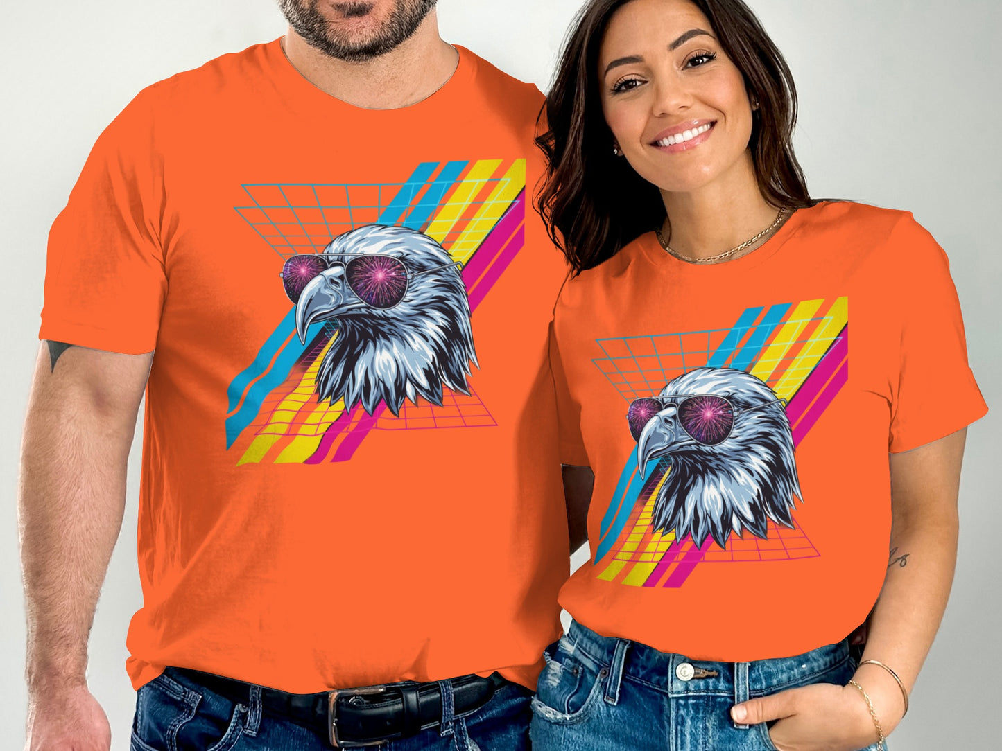 Orange t-shirts featuring an eagle head with sunglasses against a grid and colorful stripes.
