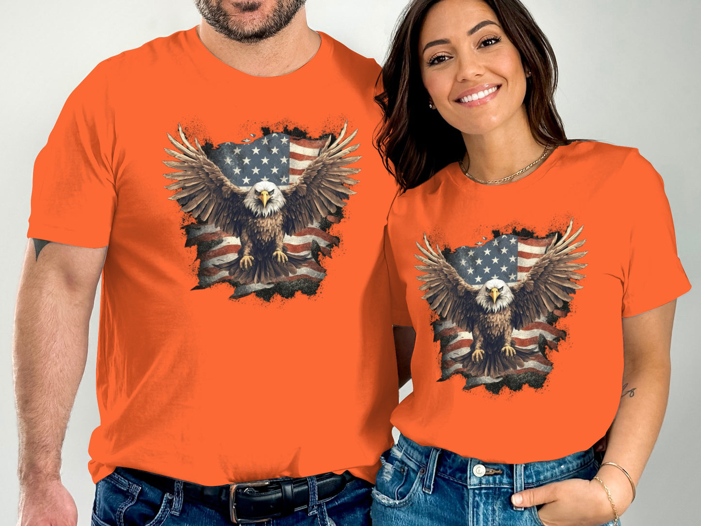 Couple wearing orange t-shirts featuring a distressed American flag and eagle graphic.