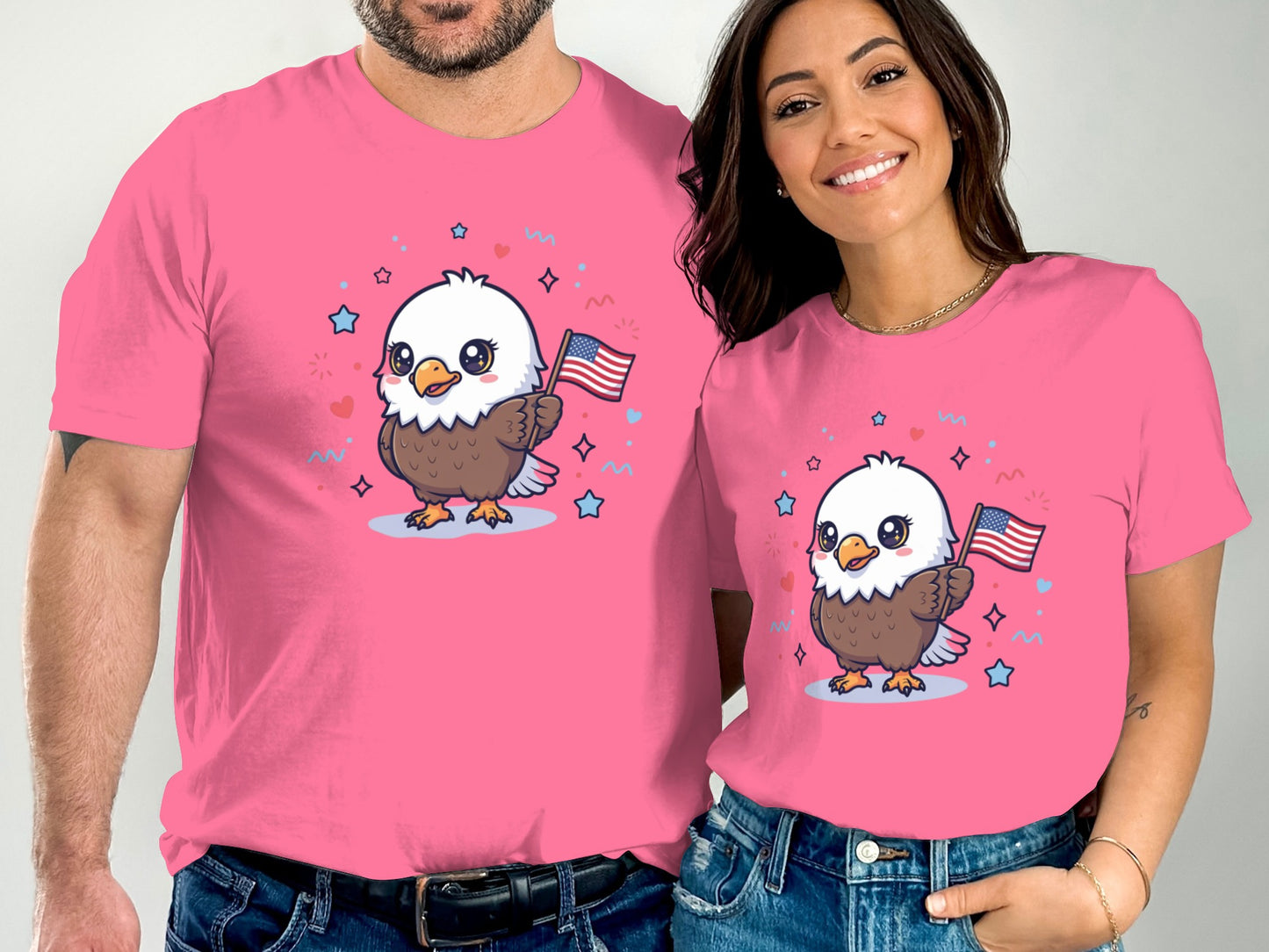 Two people wear pink t-shirts featuring an adorable cartoon eagle holding an American flag.