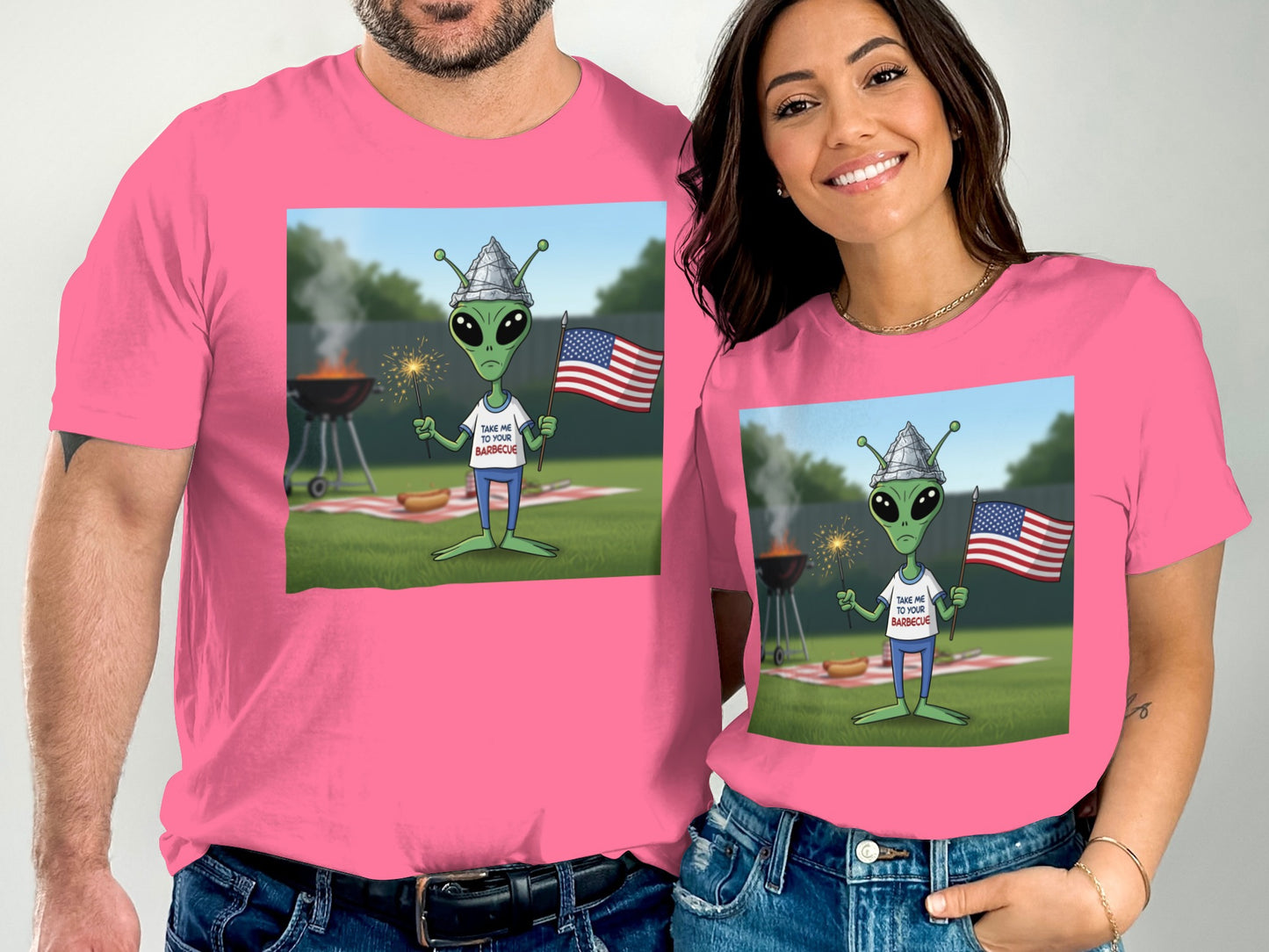 Man and woman wearing pink t-shirts with an alien at a barbecue.