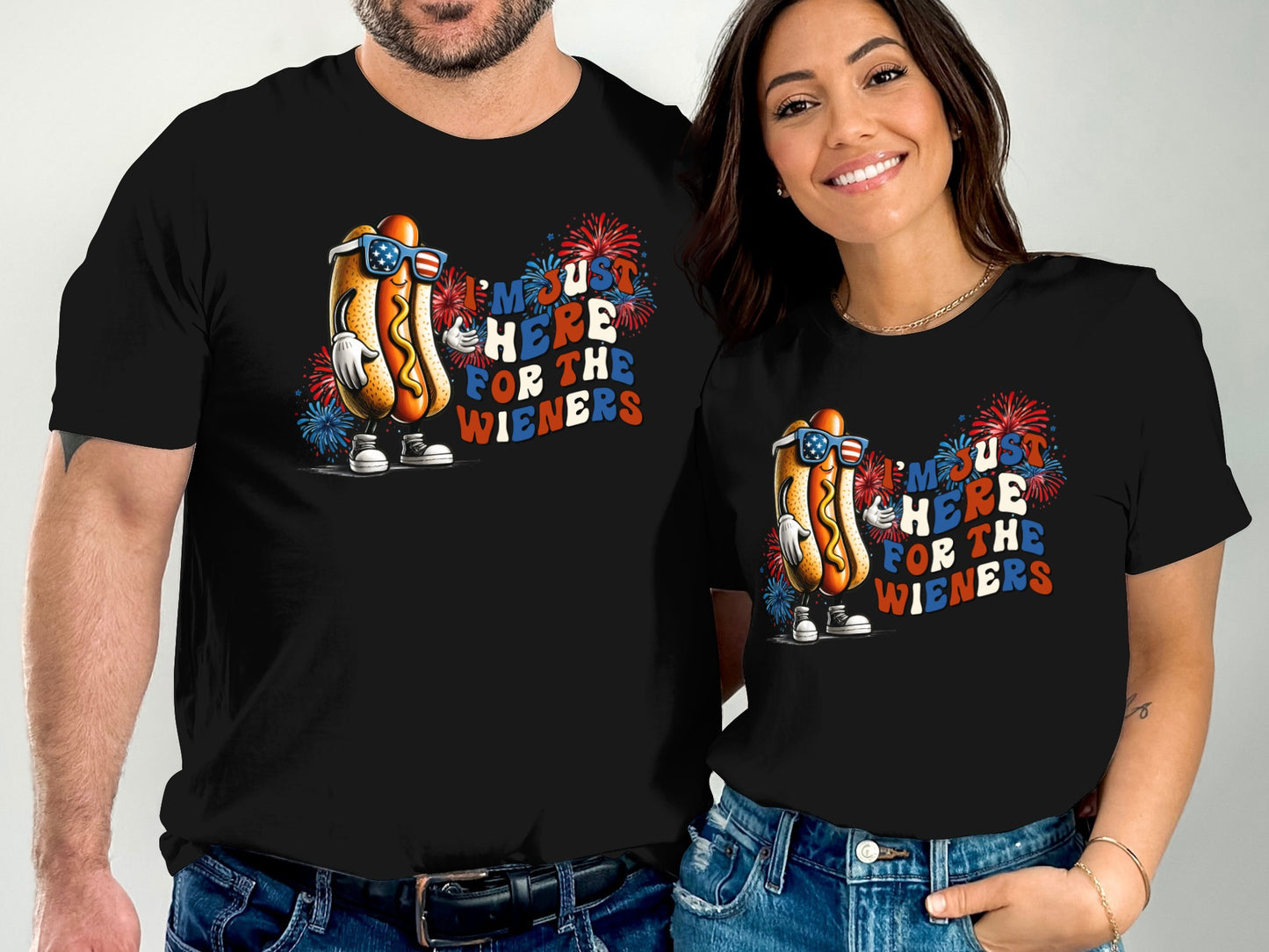 Couple wearing matching black t-shirts with a patriotic hot dog graphic.