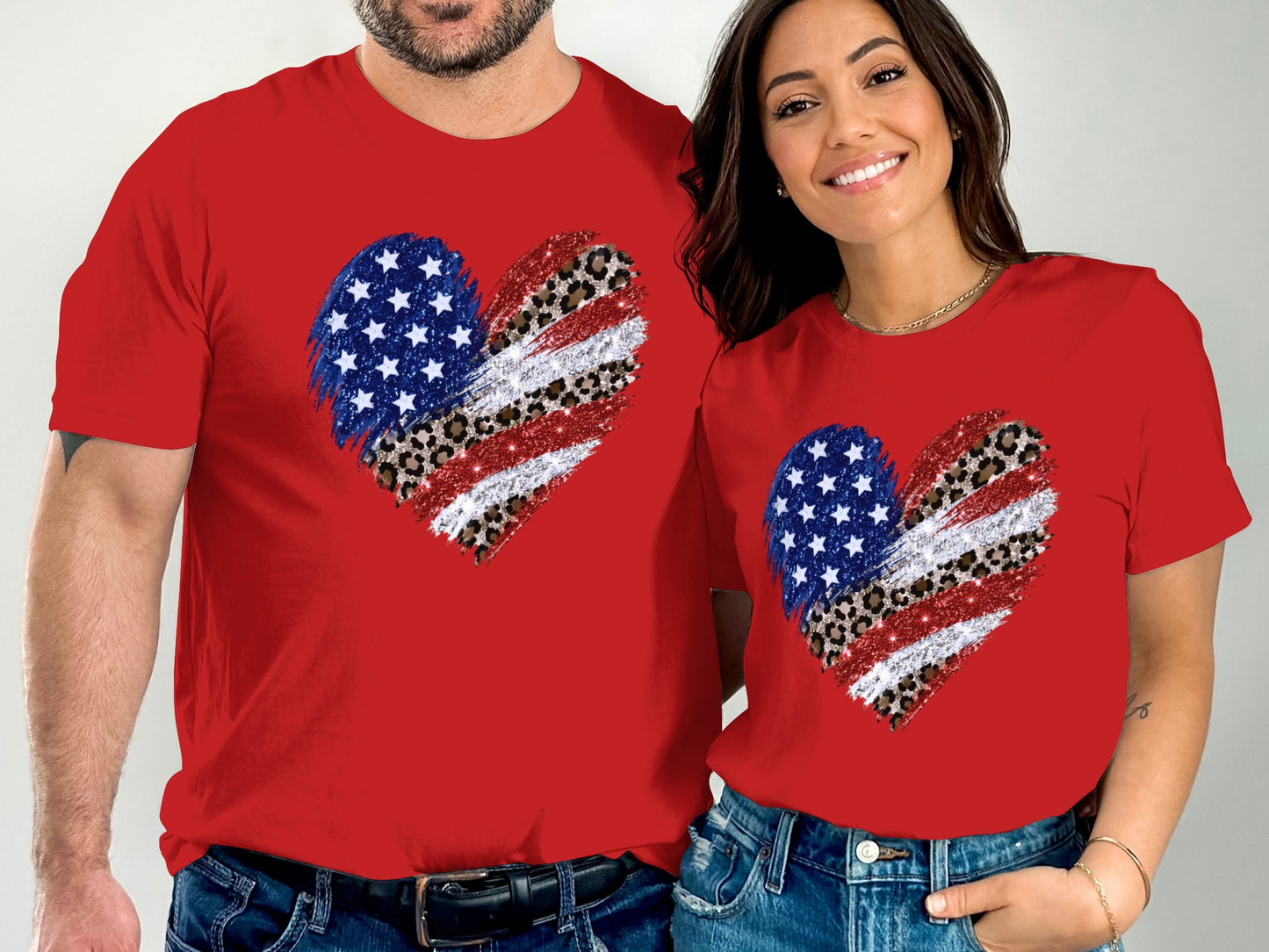 Couple in red shirts with American flag and leopard print heart graphic.