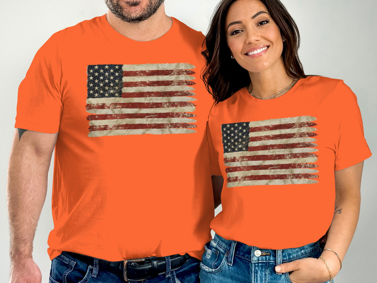 Two people wear orange t-shirts with distressed American flag designs.
