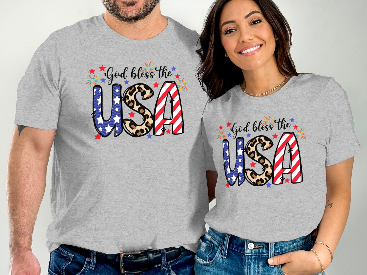 Couple wearing matching grey t-shirts with "God bless the USA" and patriotic designs.