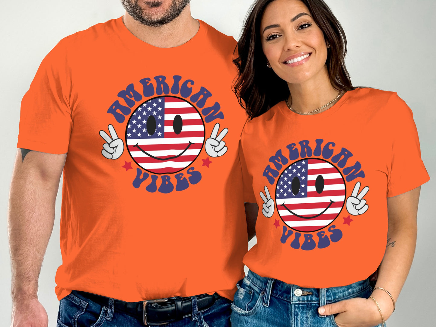 Couple wearing orange t-shirts with American flag smiley face and text "American Vibes."