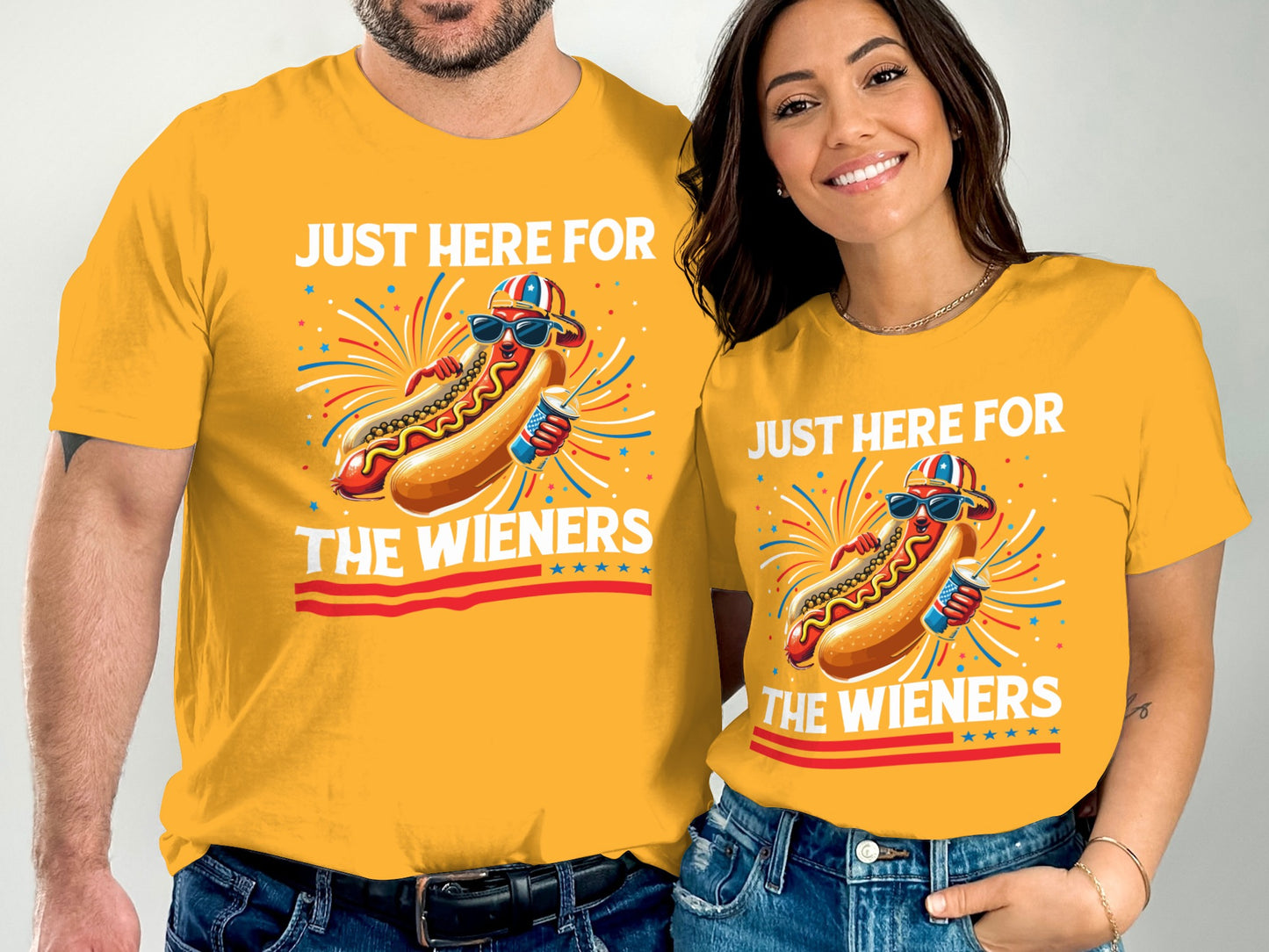 Couple in matching yellow shirts with hot dog graphic and text "Just Here For The Wieners".
