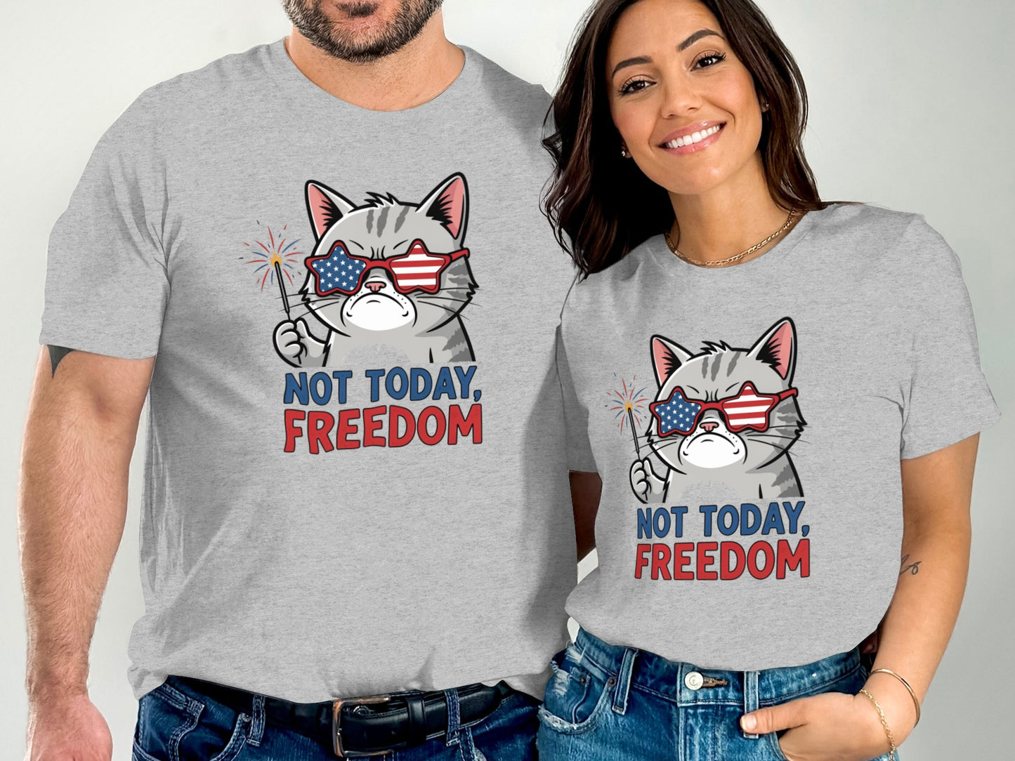 Two people wear gray t-shirts with a patriotic cat graphic and text "NOT TODAY, FREEDOM".