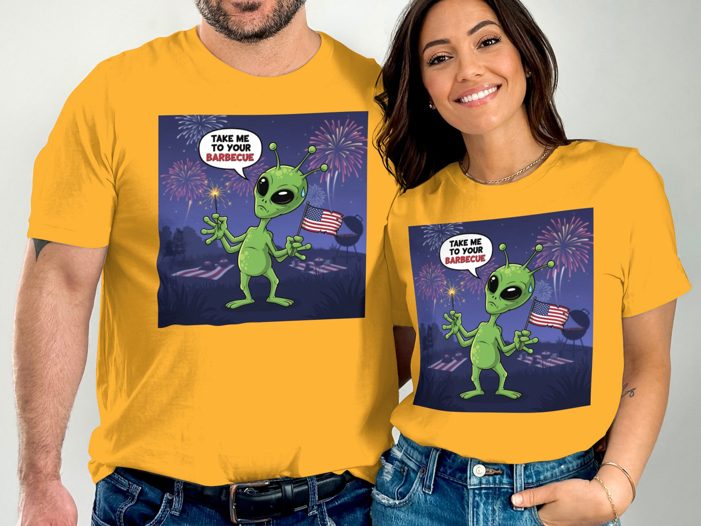 Couple in yellow t-shirts featuring a cartoon alien and fireworks.