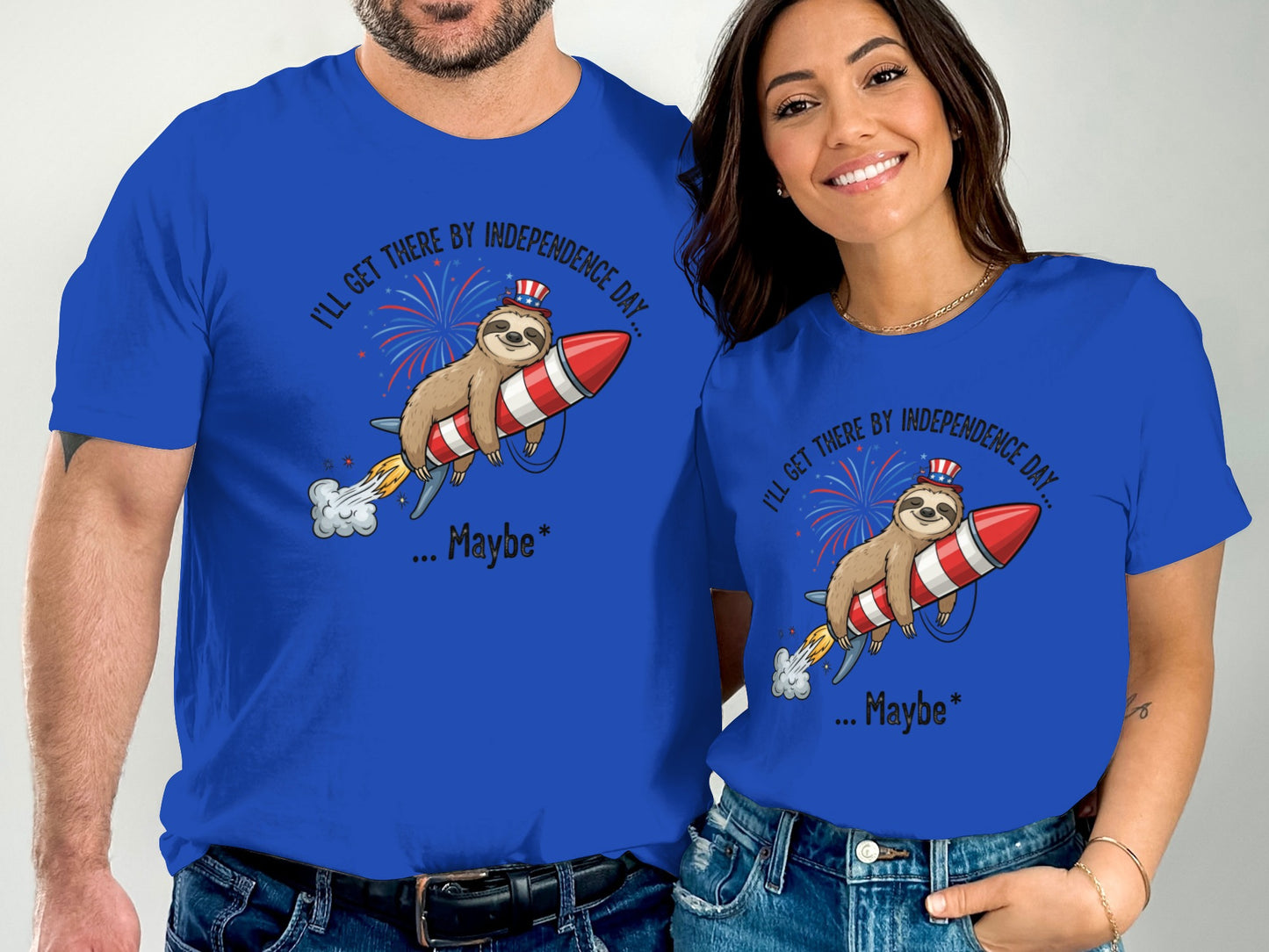 Two people wear blue t-shirts with a sloth riding a rocket and "Independence Day" text.