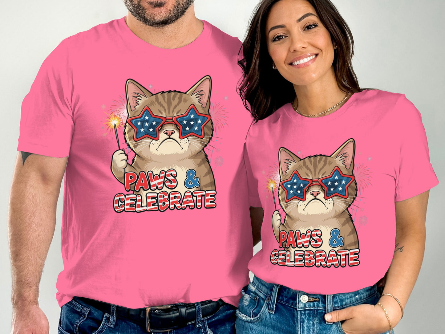 Couple wearing pink t-shirts with patriotic cat graphic and "Paws & Celebrate" text.