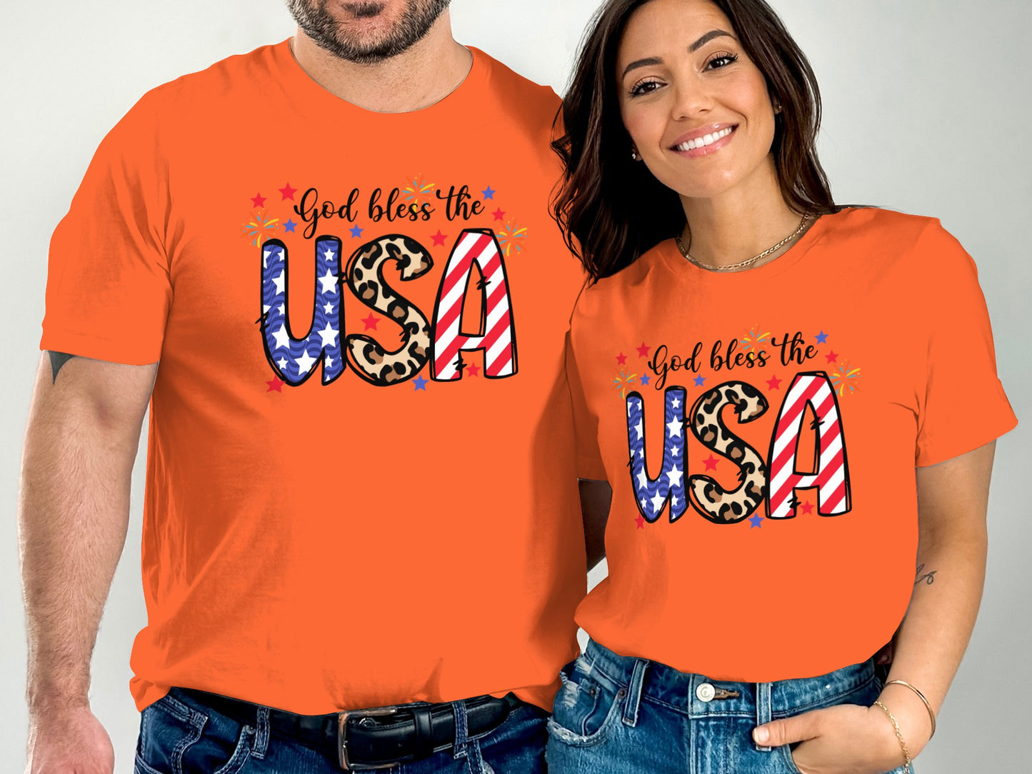 Couple in orange t-shirts with "God bless the USA" text and American flag stars and stripes.