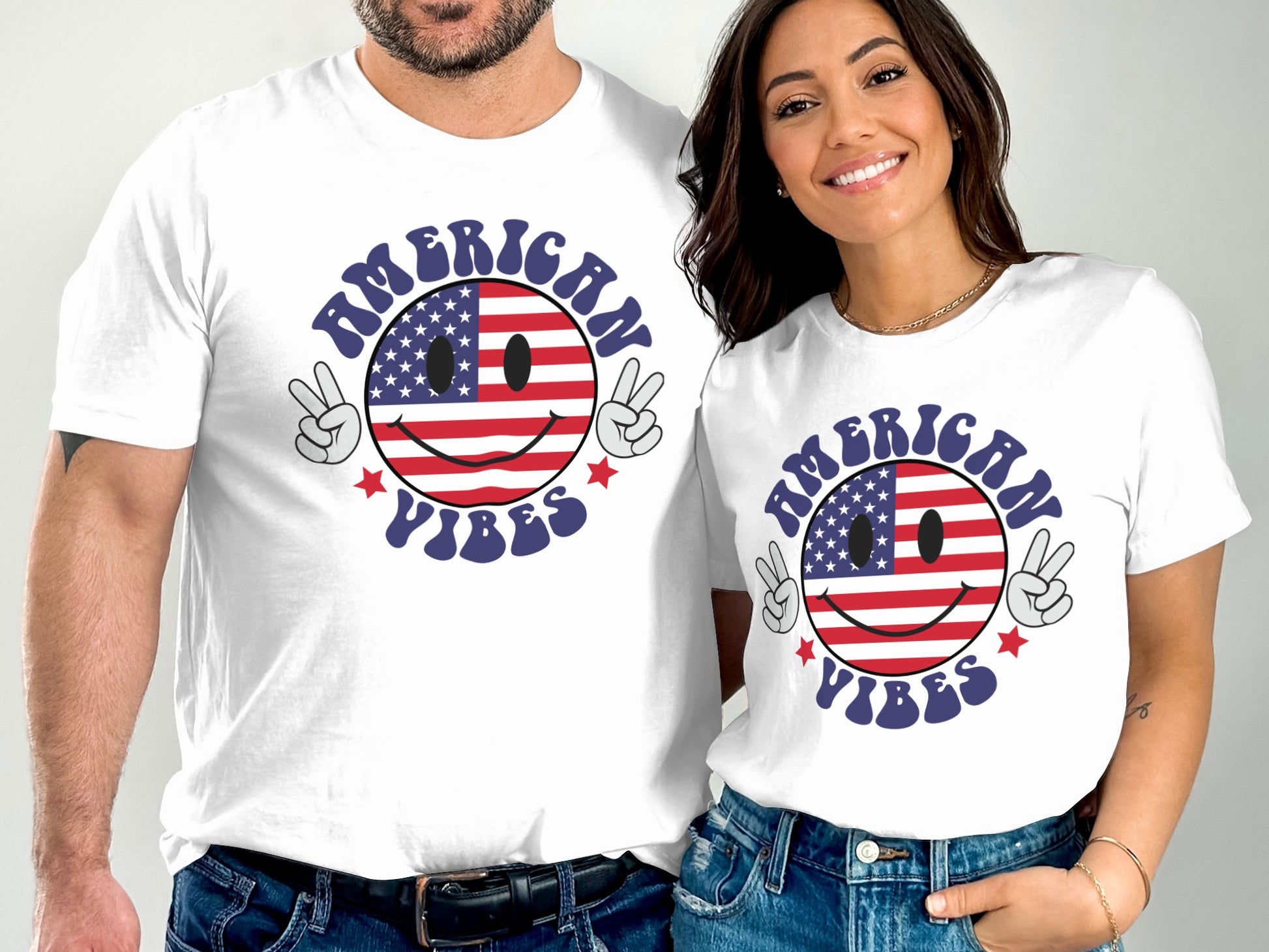 Two people wearing white t-shirts with American flag smiley face and "American Vibes" text.