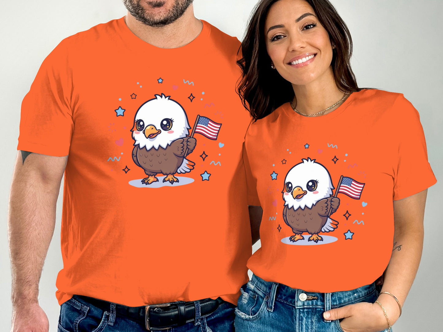 Two people in orange t-shirts featuring a cartoon eagle holding an American flag.