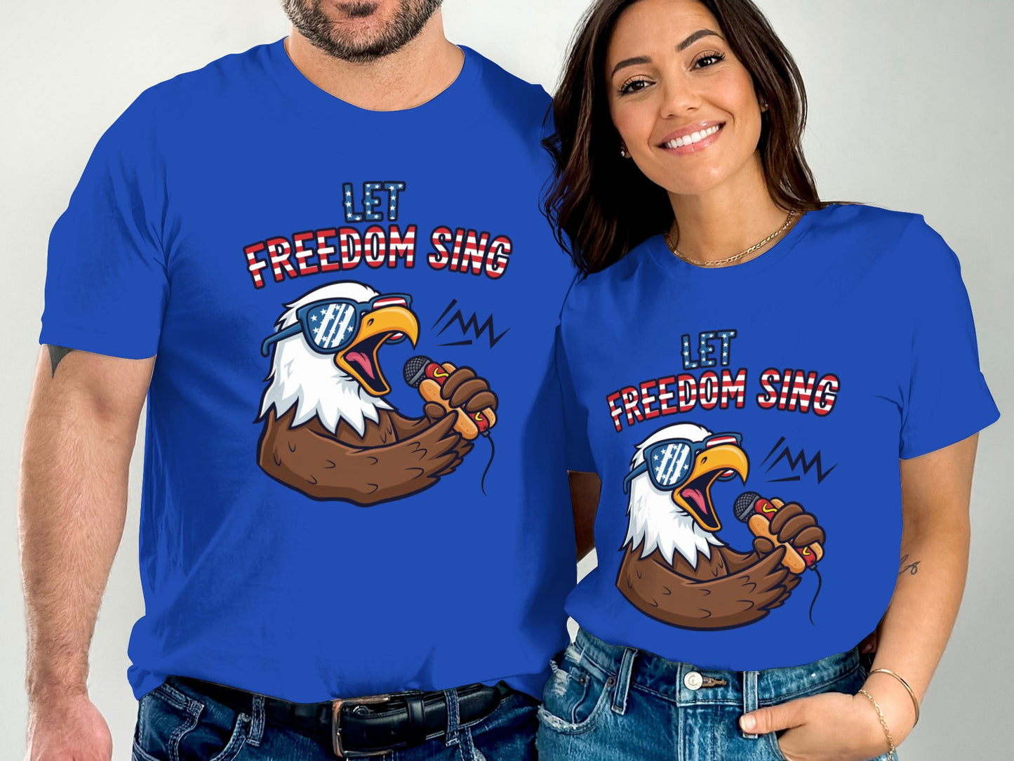 Couple wearing blue t-shirts with "LET FREEDOM SING" and eagle graphic.