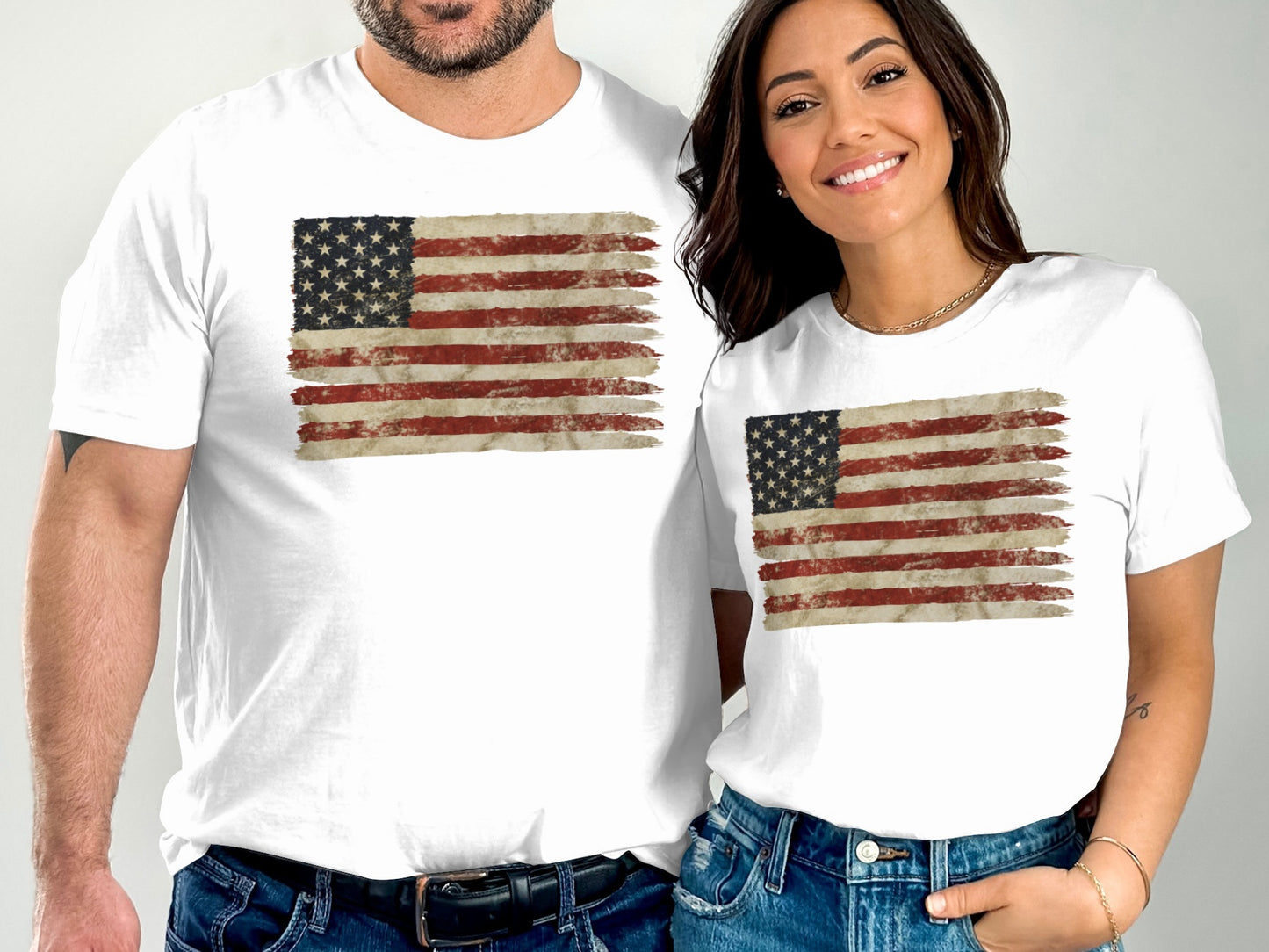 Two people wear white t-shirts with a distressed American flag graphic.