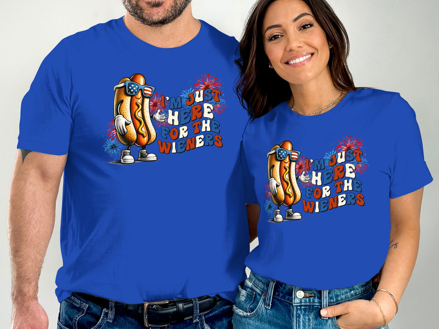 Couple wearing matching "I'm just here for the wieners" hot dog t-shirts.