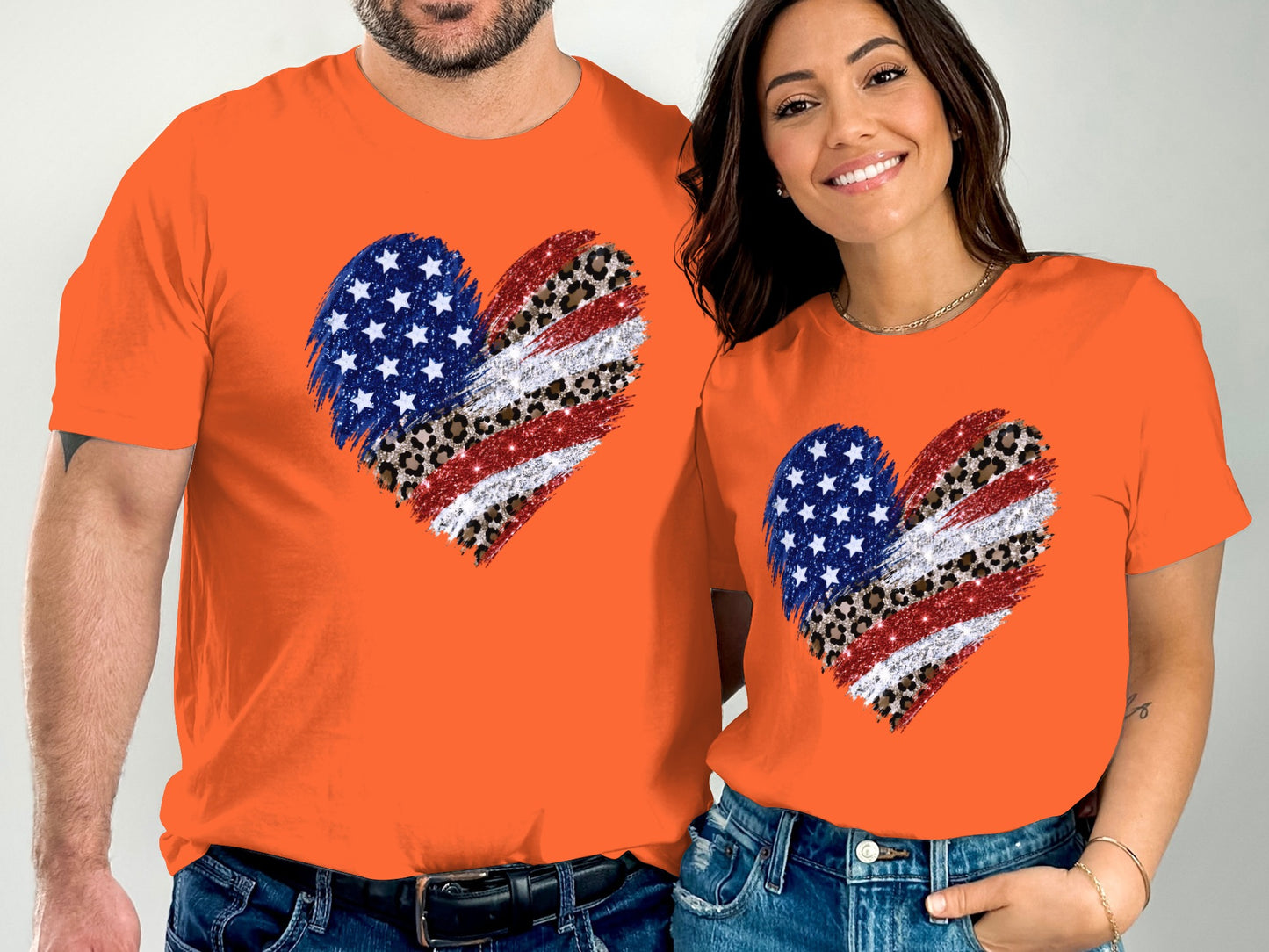 Couple wearing matching orange t-shirts with American flag heart graphic.