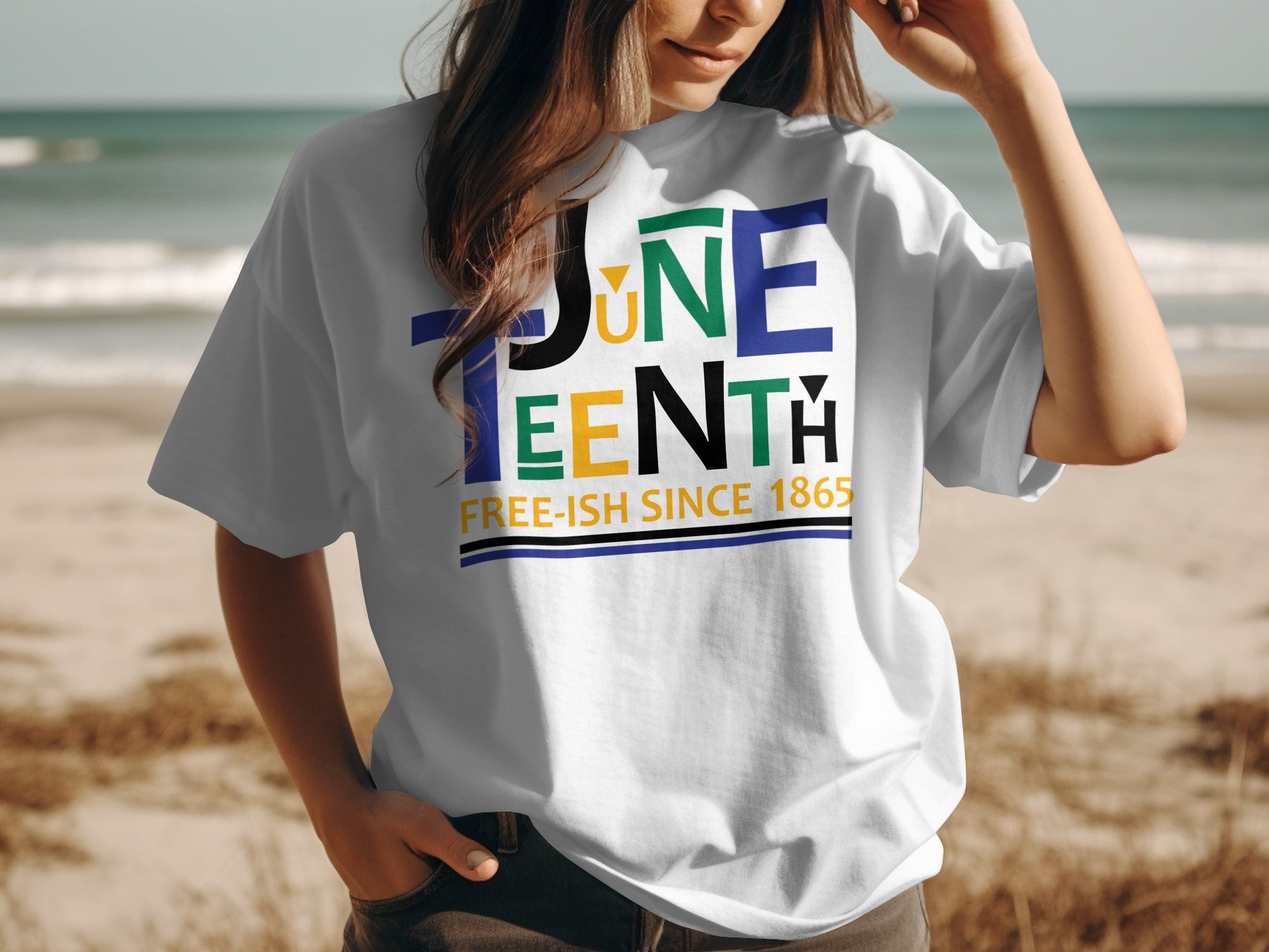White Juneteenth T-Shirt with colorful text design and Free-ish Since 1865 slogan worn at the beach